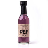 Clear glass bottle with black top filled with 5 oz. of Lavender Syrup