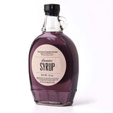 Clear glass bottle with black top filled with 12 oz. Lavender Syrup